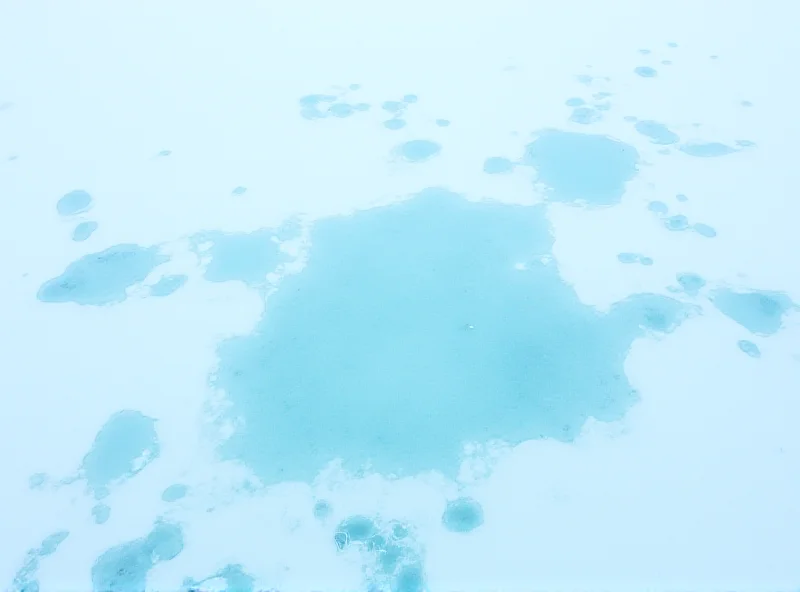 Aerial view of melting ice in Greenland with blue meltwater pools